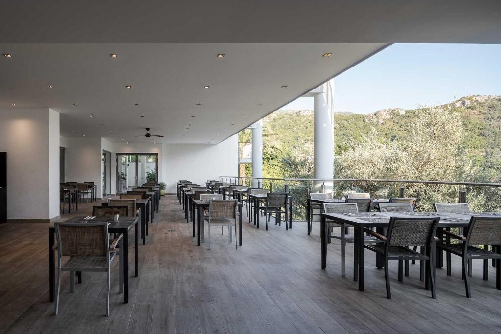 a dining room with tables and chairs and a balcony at Eurostars Queen of Montenegro in Budva