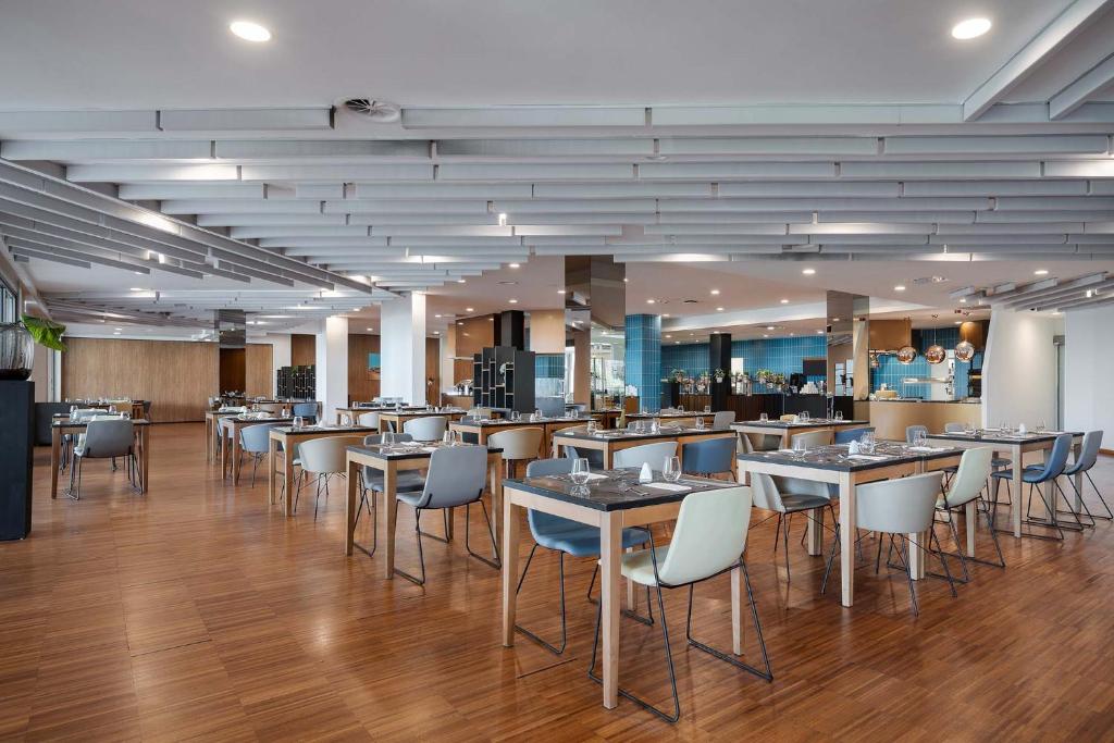 a restaurant with tables and chairs in a room at Eurostars Queen of Montenegro in Budva