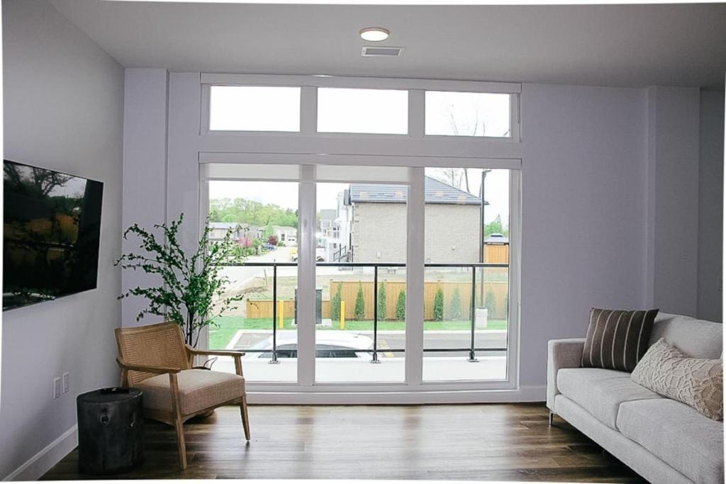 a living room with a couch and a large window at Beachview getaway at the New Carlyle 200 on the Main strip in Grand Bend in Grand Bend