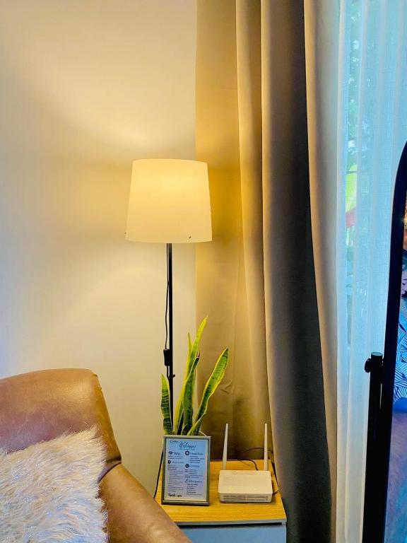 a lamp sitting on a table next to a bed at Karlana Breeze 101 in Cabug