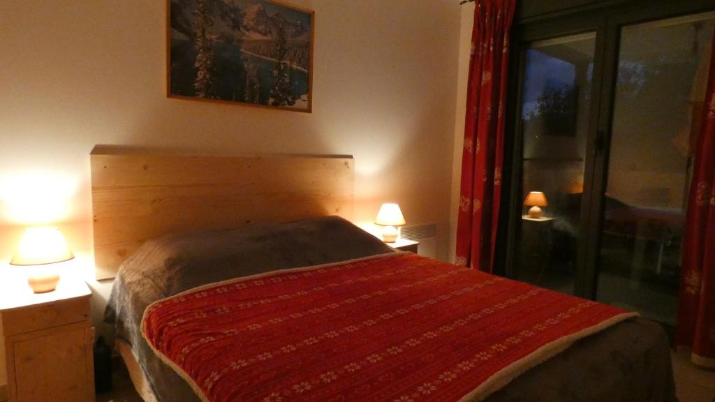 une chambre avec un lit avec une couverture rouge dessus dans l'établissement Superbe T2 avec coin montagne à 2 pas des pistes et des sentiers de randonnée, à Briançon