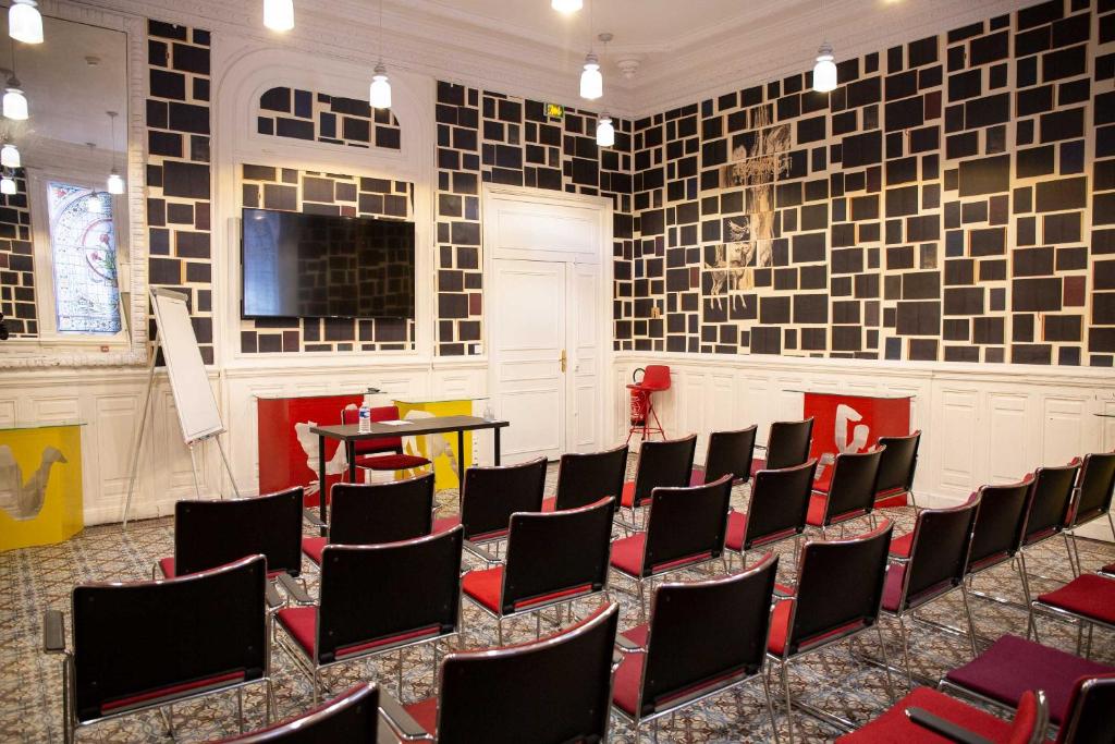 a room with a bunch of chairs and a tv at Grand Hôtel du Midi Montpellier - Opéra Comédie in Montpellier