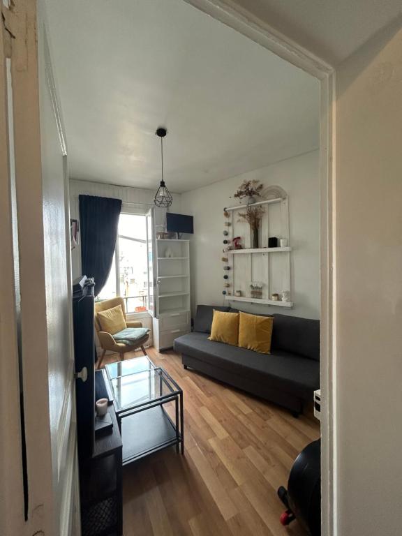 un salon avec un canapé et une table en verre dans l'établissement Appartement Porte de Versailles, à Vanves