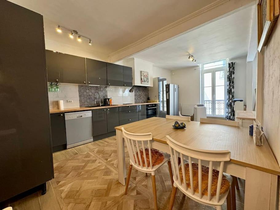 une grande cuisine avec une table et des chaises en bois dans l'établissement Le Refuge du Coquelicot, à Béziers