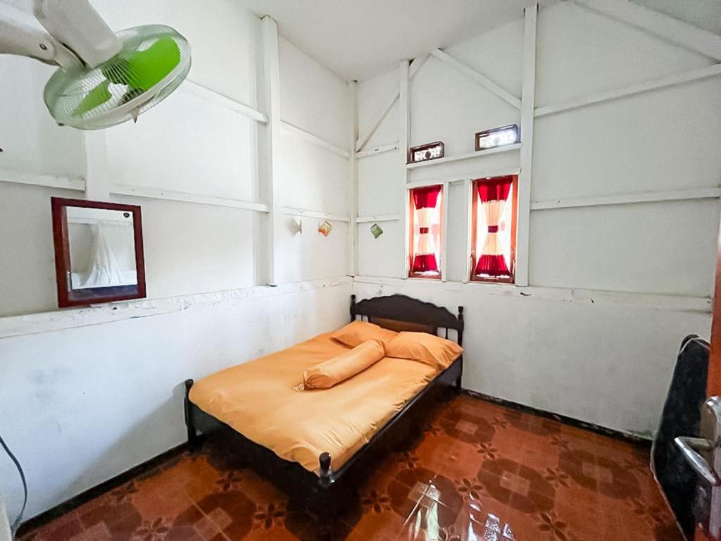 a bedroom with a bed in a room with two windows at Penginapan,Villa dan Homestay Geopark Ciletuh in Cilowa