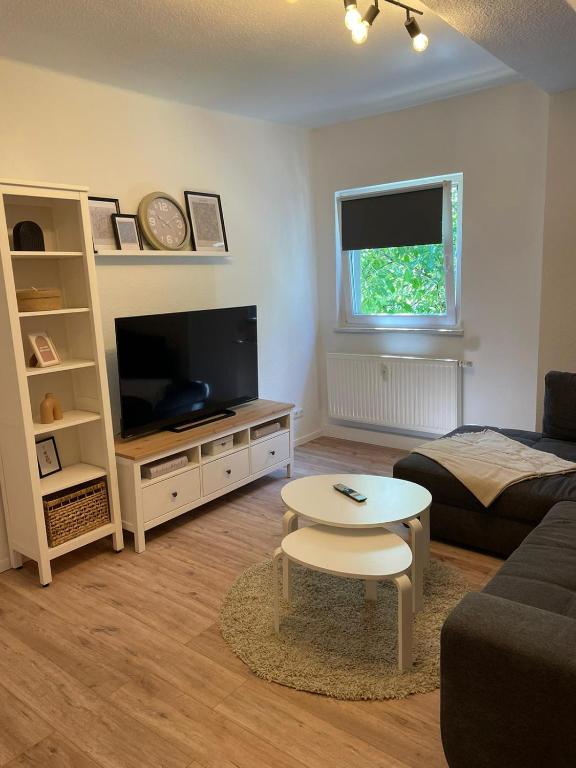 a living room with a couch and a television at Branderodaer Ferienwohnung in Baumersroda