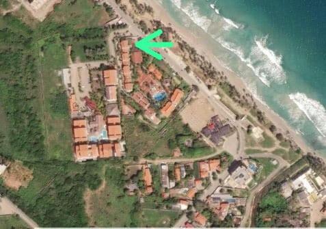 La LomaにあるApartamento en puerta del solのビーチの建物の上にある緑色の×印