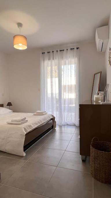 une chambre blanche avec un lit et une fenêtre dans l'établissement Appartement de la plage, à Solaro