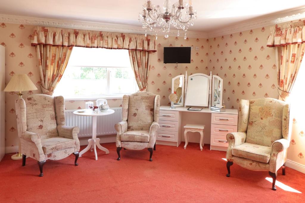 a bathroom with a vanity and chairs and a mirror at Meadowside B&B in Bunclody