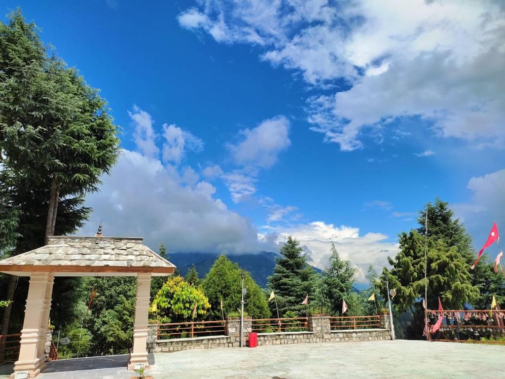 a gazebo in a park under a blue sky at Durgadevi Guesthouse by StayApart in Rudraprayāg