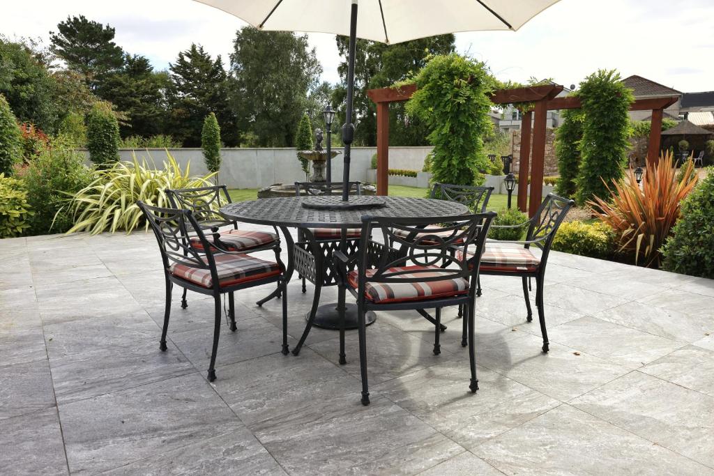 a table and chairs with an umbrella on a patio at Meadowside B&B in Bunclody