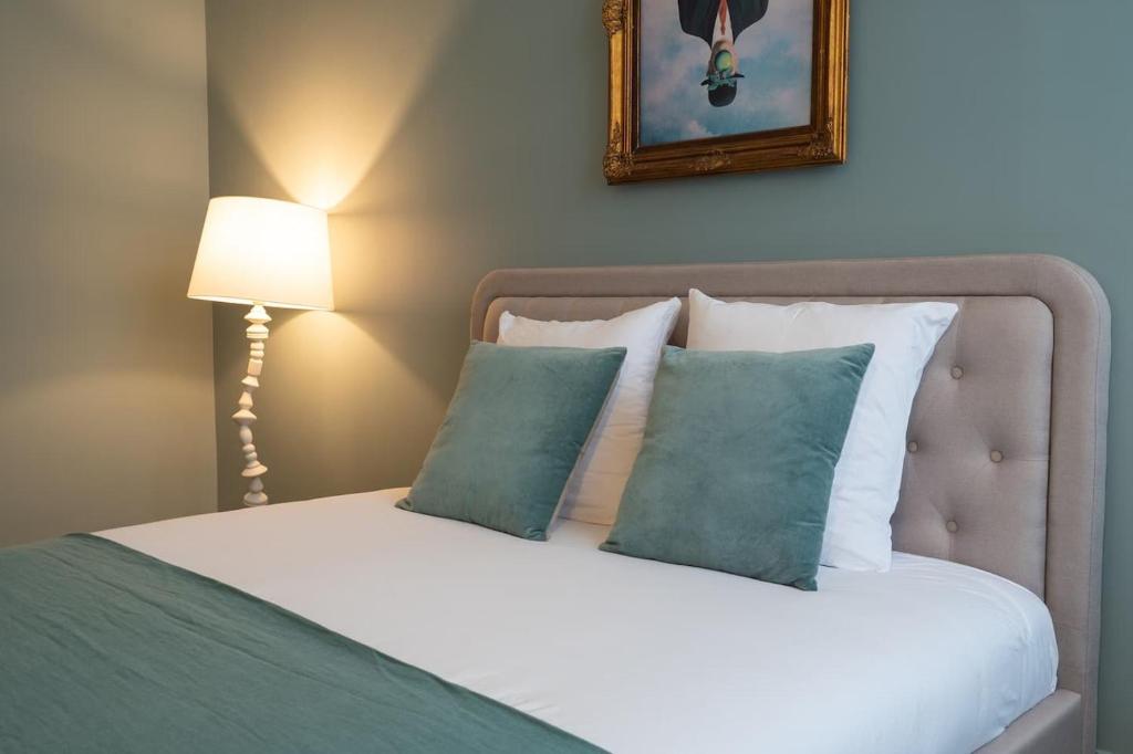 a bedroom with a bed with two pillows and a lamp at Le Dada 6 personnes hypercentre Epernay in Épernay