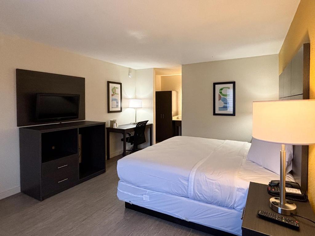 a hotel room with a bed and a flat screen tv at Motel 6 Charlotte, NC Northlake in Charlotte