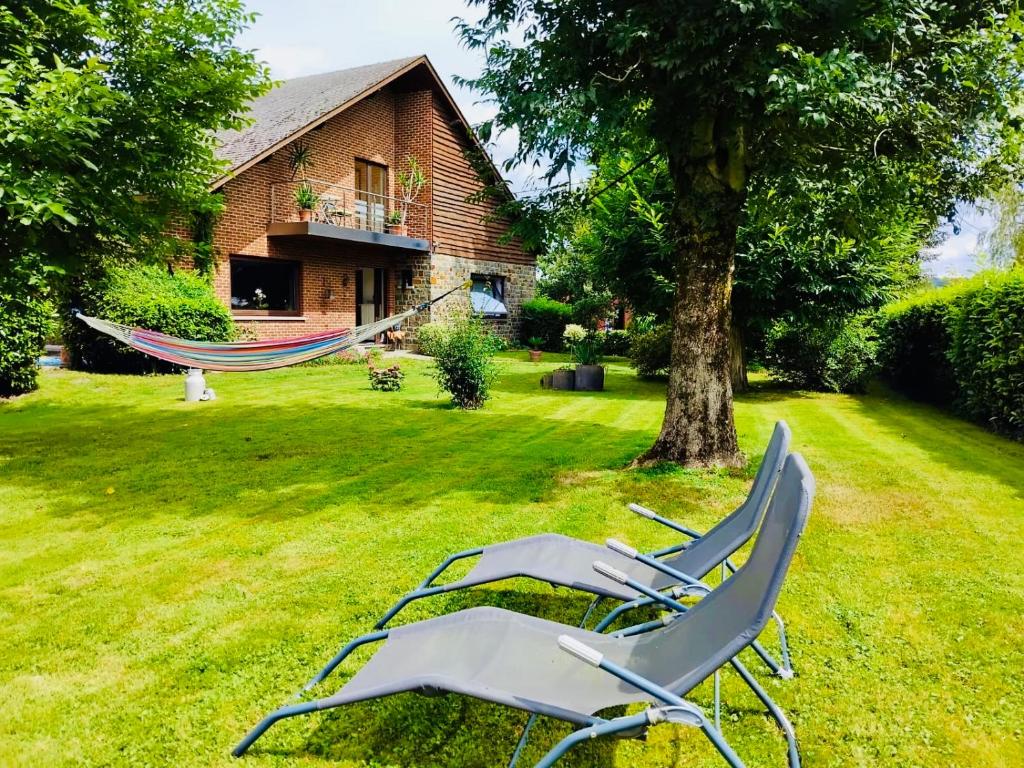 two lawn chairs and a hammock in a yard at Les Églantines in Marche-en-Famenne