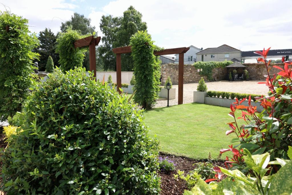 a garden with a pergola and grass at Meadowside B&B in Bunclody