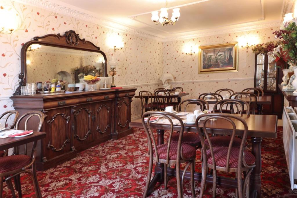 a dining room with a table and chairs and a mirror at Meadowside B&B in Bunclody