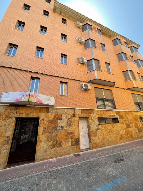 a large brick building with a sign in front of it at Edificio Primavera Viviendas turísticas in Calasparra