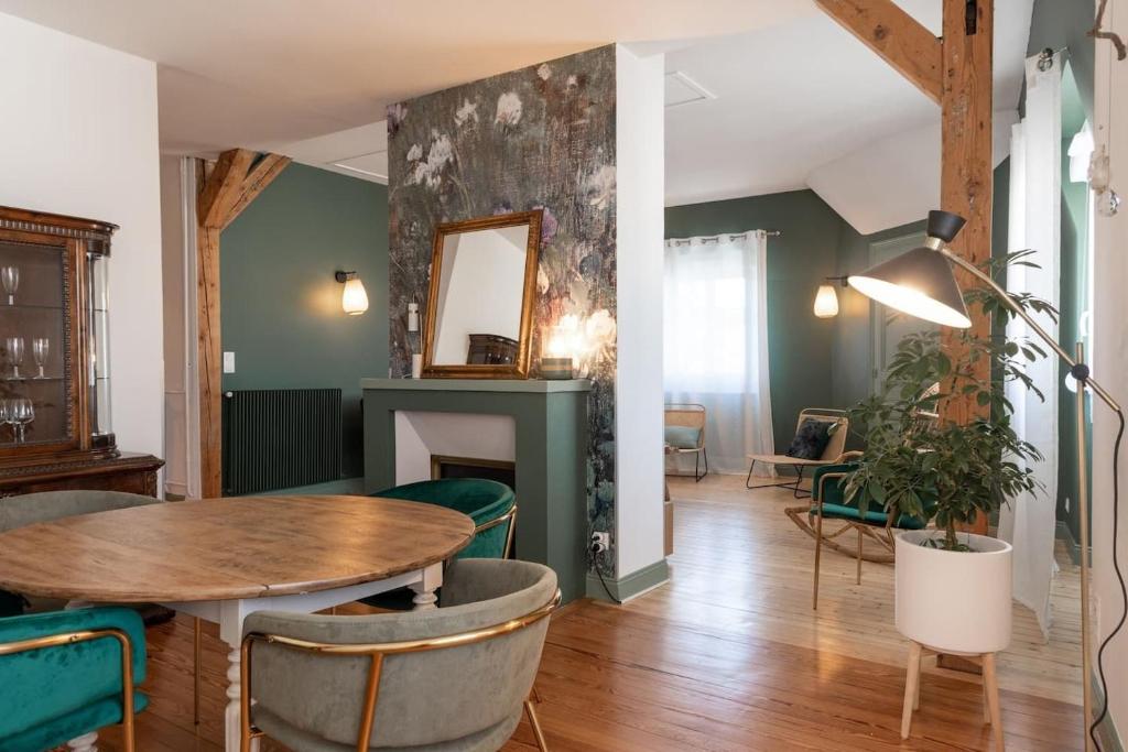 - un salon avec une table et des chaises vertes dans l'établissement Le Leon Bourgeois 6 personnes hypercentre Epernay, à Épernay