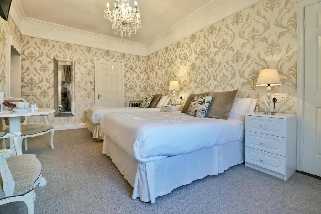 a bedroom with two beds and a chandelier at Meadowside B&B in Bunclody