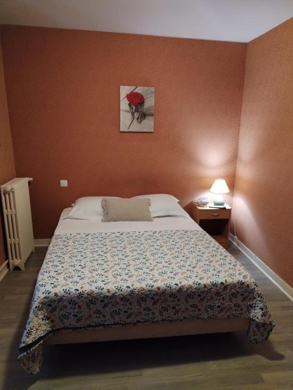 a bedroom with a bed and a picture on the wall at Aux Trois Rois in Pont-sur-Yonne