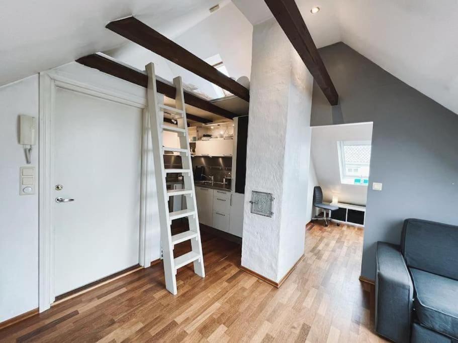 a loft room with a ladder and a living room at Apartment with Loft & Window Balcony, Free parking in Bergen