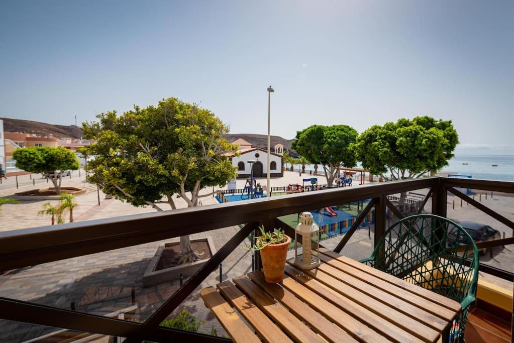 a wooden bench sitting on a balcony next to a pool at Apartamento La Falúa in Lajita