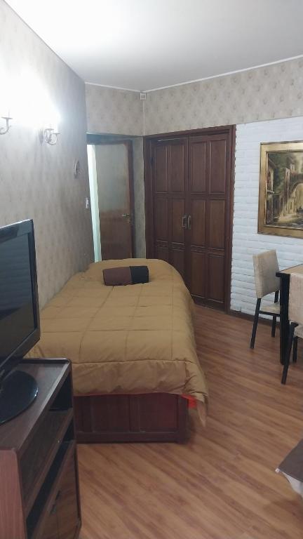 a bedroom with a bed and a flat screen tv at Gustavo in Villa Mercedes