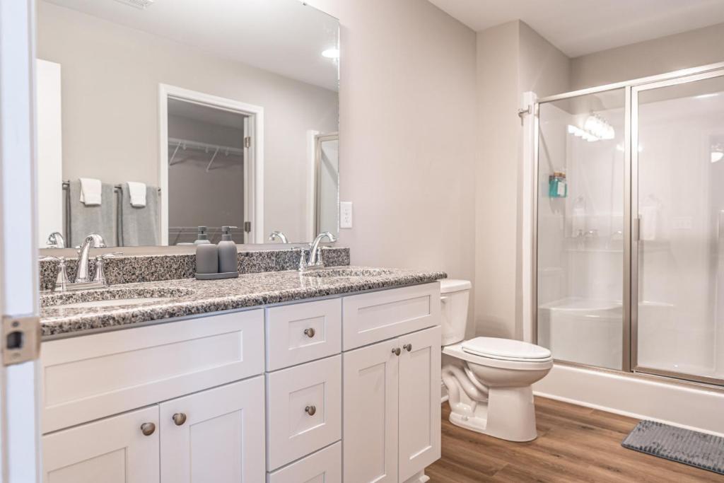a white bathroom with a toilet and a shower at The Dogwood at Ducks Landing in Aberdeen