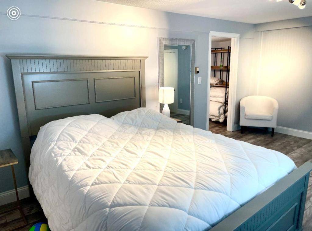 Un dormitorio con una gran cama blanca en una habitación. en 1 Bedroom, steps to the Beach, en Old Orchard Beach