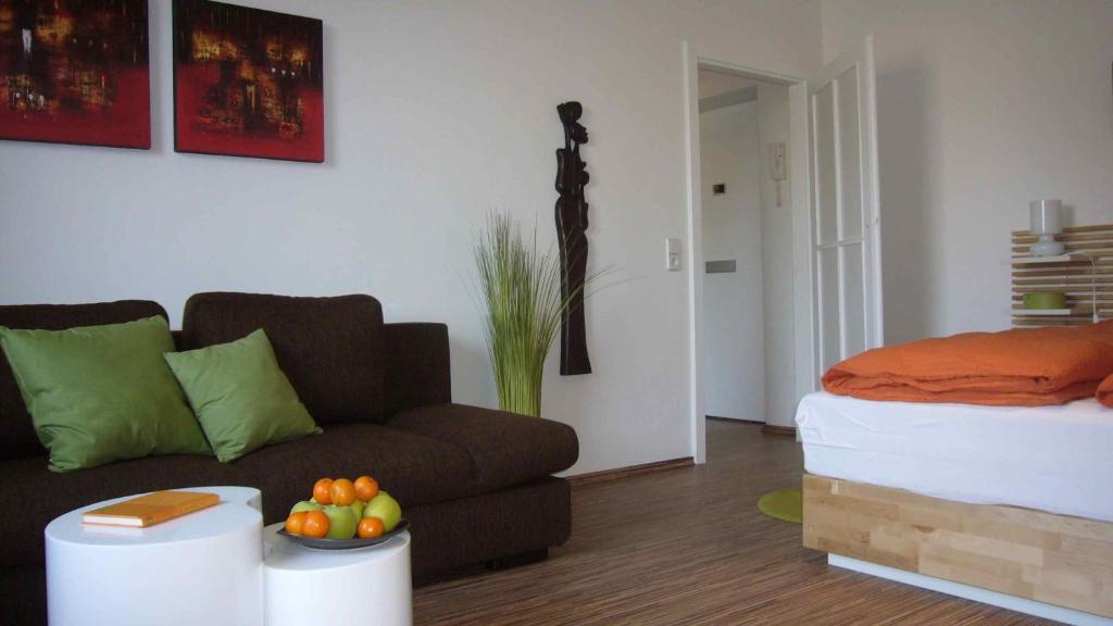 ein Wohnzimmer mit einem Sofa und einem Bett in der Unterkunft Apartment Hochbründl in Mödling