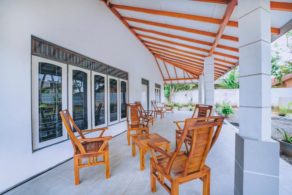 a row of wooden chairs on a porch at Shinestar Villa Mirissa in Mirissa