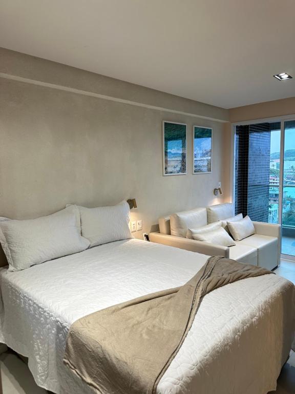 een slaapkamer met een groot bed en een bank bij RN Studio Premium 505 - Vista Mar in Maceió
