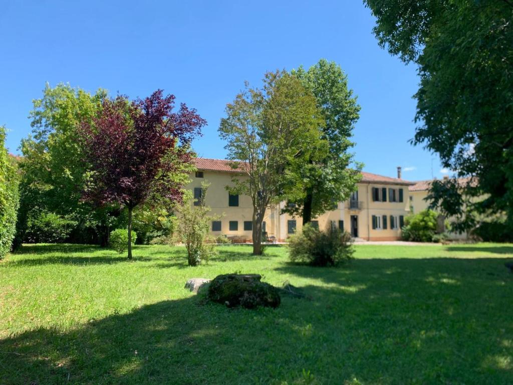 Santo Stéfano UdineseにあるVilla d'Arcano-3 camere-Ampio giardinoの建物前の芝生に寝た犬