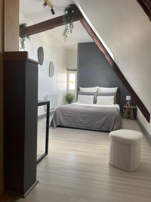 - une chambre avec un lit et un tabouret dans l'établissement Duplex bord de l'Eure - Parking inclus - Jolie vue sur la cathédrale, à Chartres