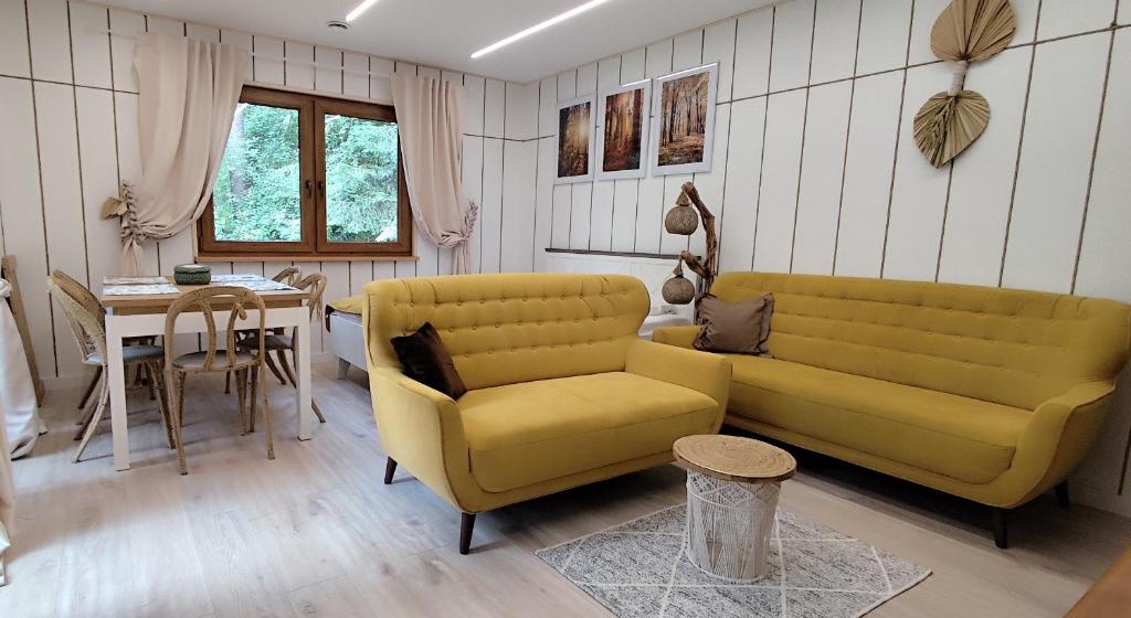 a living room with a yellow couch and a table at Jutowa Chata - nocleg bliżej natury in Łask