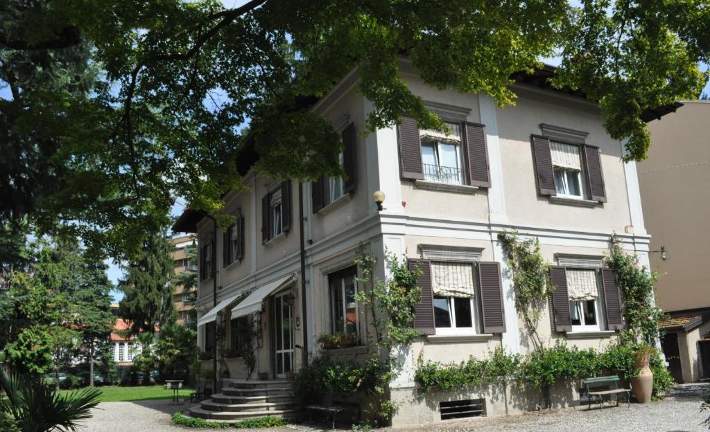 ein großes weißes Haus mit braunen Fensterläden in der Unterkunft Invilla B&B in Varese