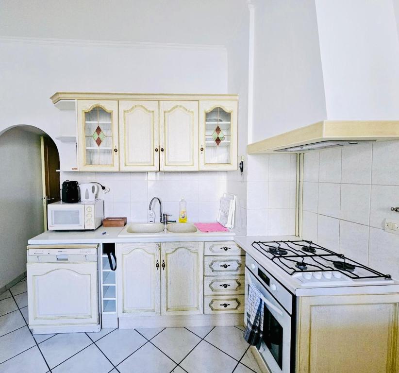 Una cocina con gabinetes blancos y un horno de estufa. en Basilique Métro 13, en Saint-Denis