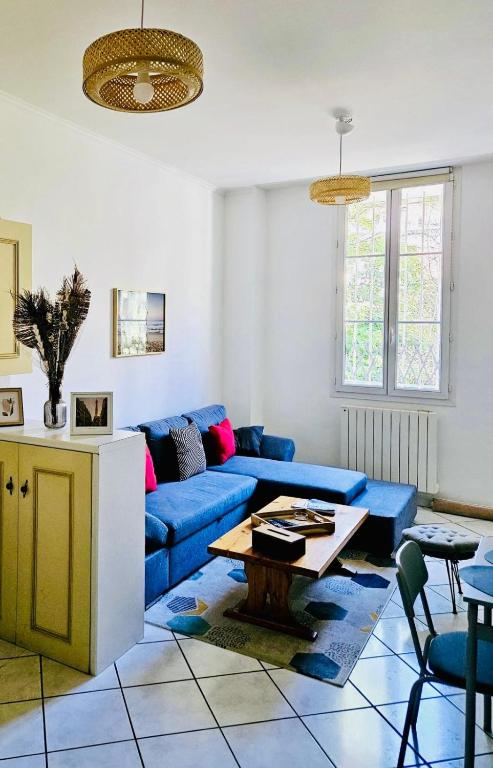 un salon avec un canapé bleu et une table dans l'établissement Basilique Métro 13, à Saint-Denis