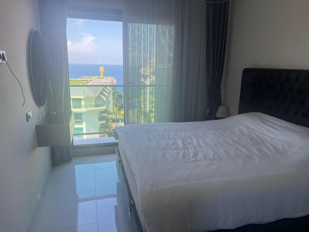 a bedroom with a bed and a window with a view at Konak premium Seaside Studio in Kargicak