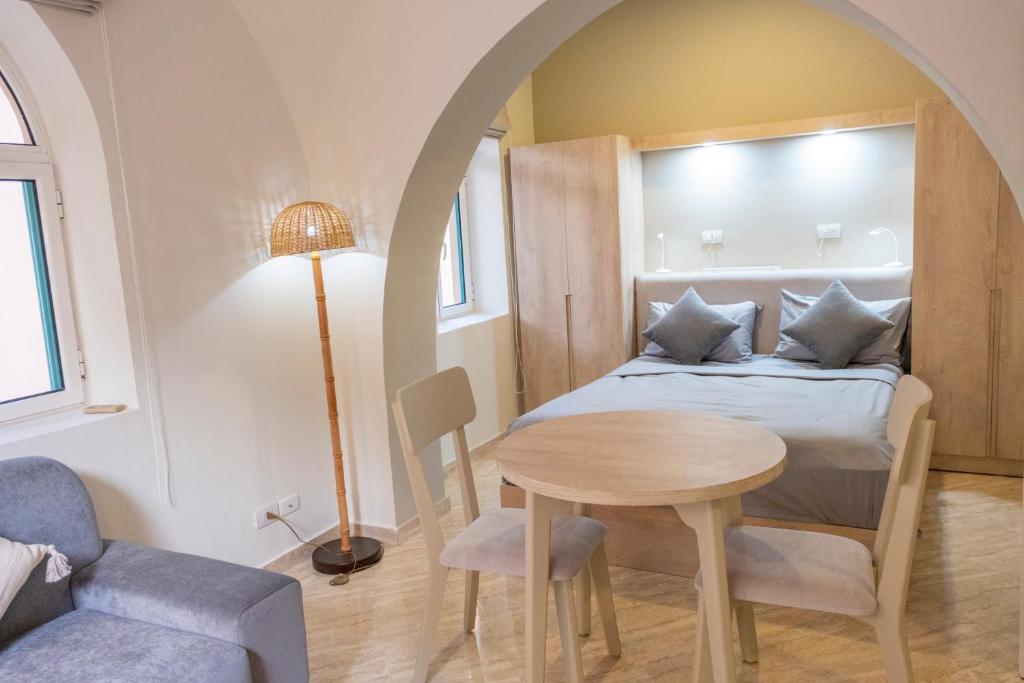 a bedroom with a bed and a table and a chair at Studio Serenity Downtown El Gouna in Hurghada