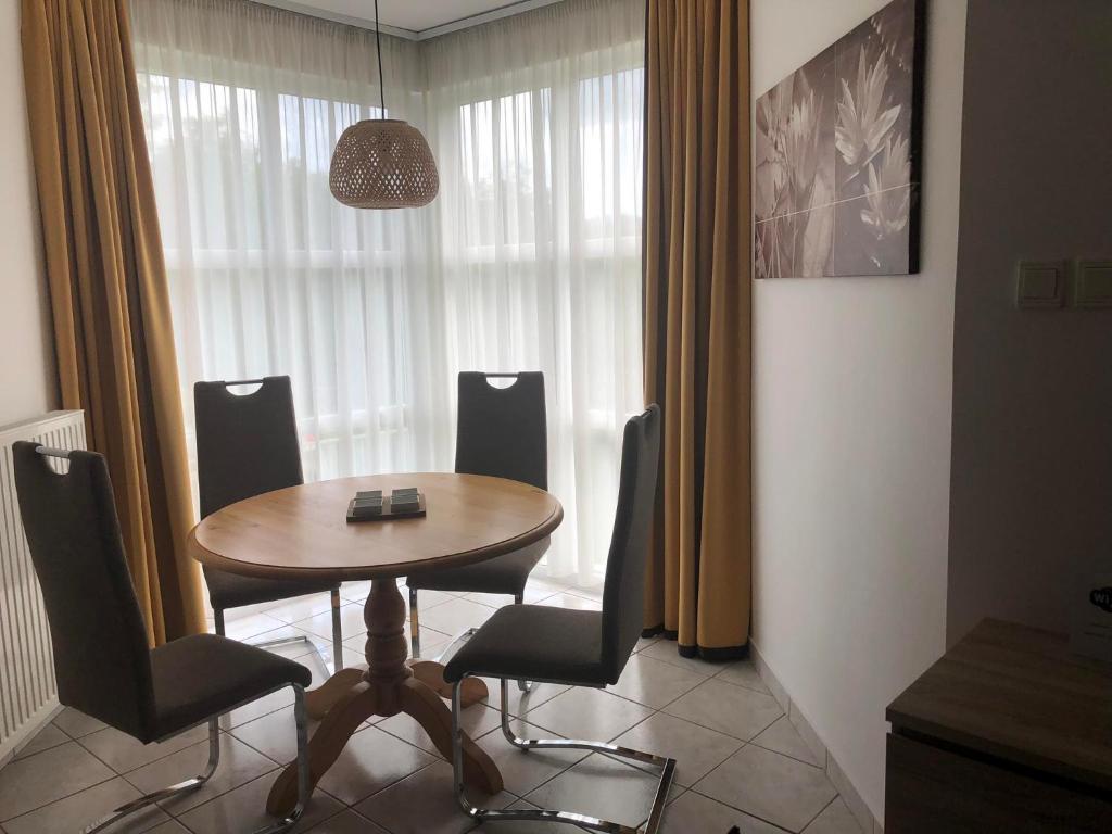a dining room table and chairs in a room at Greenhouse Apartman in Zalakaros