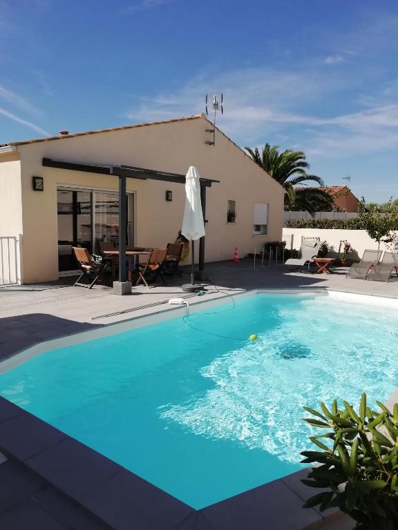 une grande piscine devant une maison dans l'établissement florensac, à Florensac