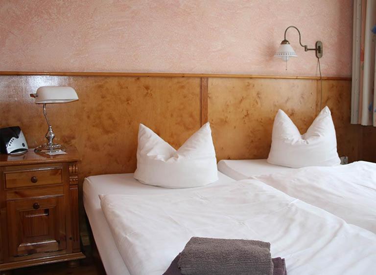 two beds with white pillows in a hotel room at Pensionszimmer Unicat in Potsdam