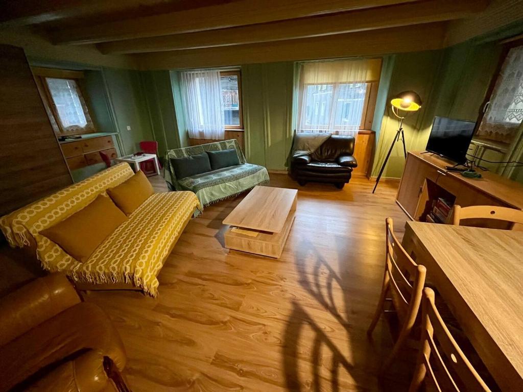 a living room with a couch and a table at Historische Maisonettewohnung bis 10 Gäste, Magic Pass Belalp, Rosswald und mehr in Naters
