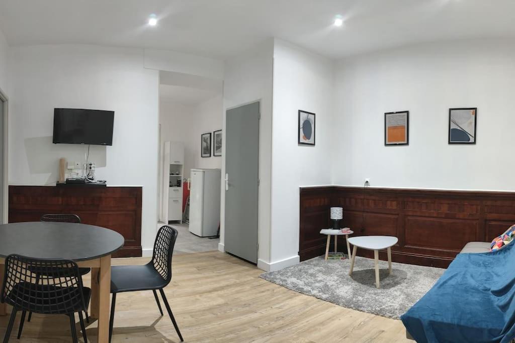 un salon avec une table et un canapé dans l'établissement Appartement La Pause Bleue, à Lourdes