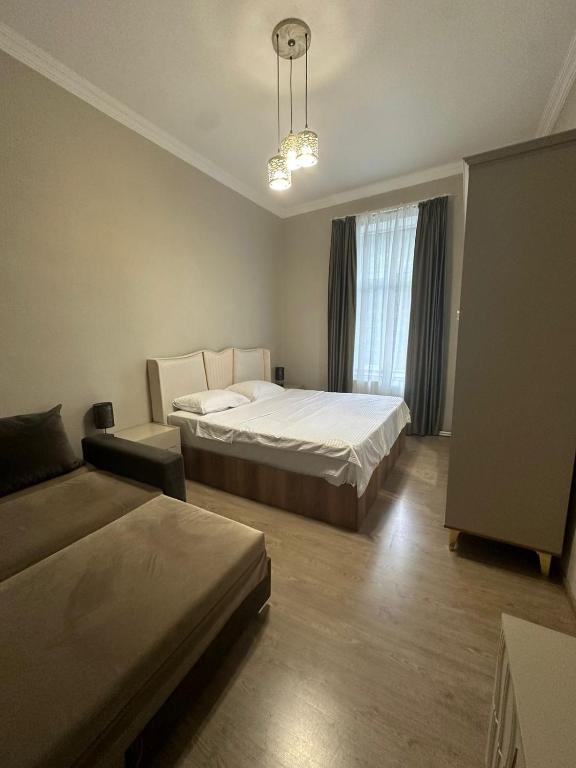 a bedroom with two beds and a couch in it at Sweet Guest House in Borjomi