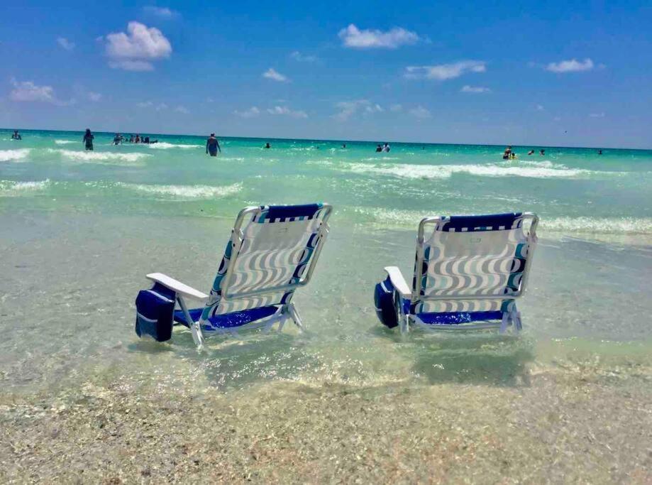 two chairs sitting in the water on a beach at Star Fish 3 Bed 2 bath POOL Walk to Beach in Sarasota