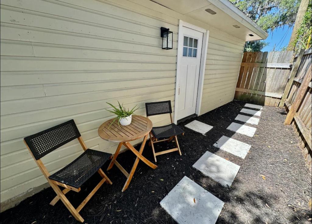 a patio with two chairs and a table with a plant at The Sanford Foodie Guest House in Sanford