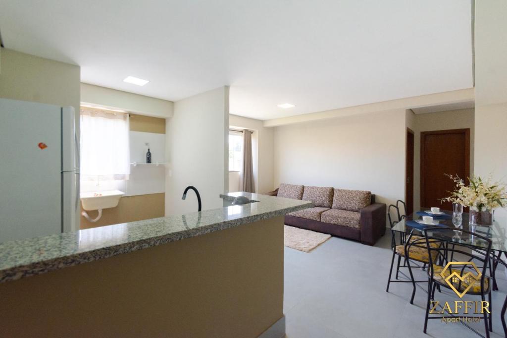 a kitchen and living room with a counter top at Zaffir Apartamento in Cuiabá