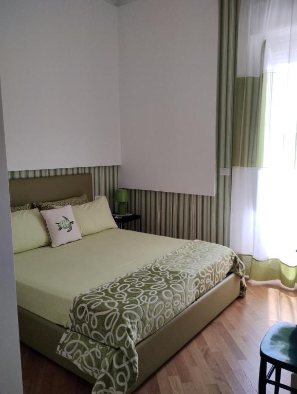 a bedroom with a large bed and a window at B&B Cèsar in Castrignano del Capo
